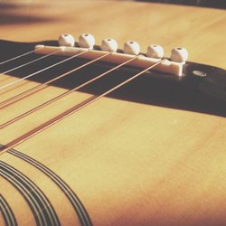 Acoustic guitar saddle on bridge.